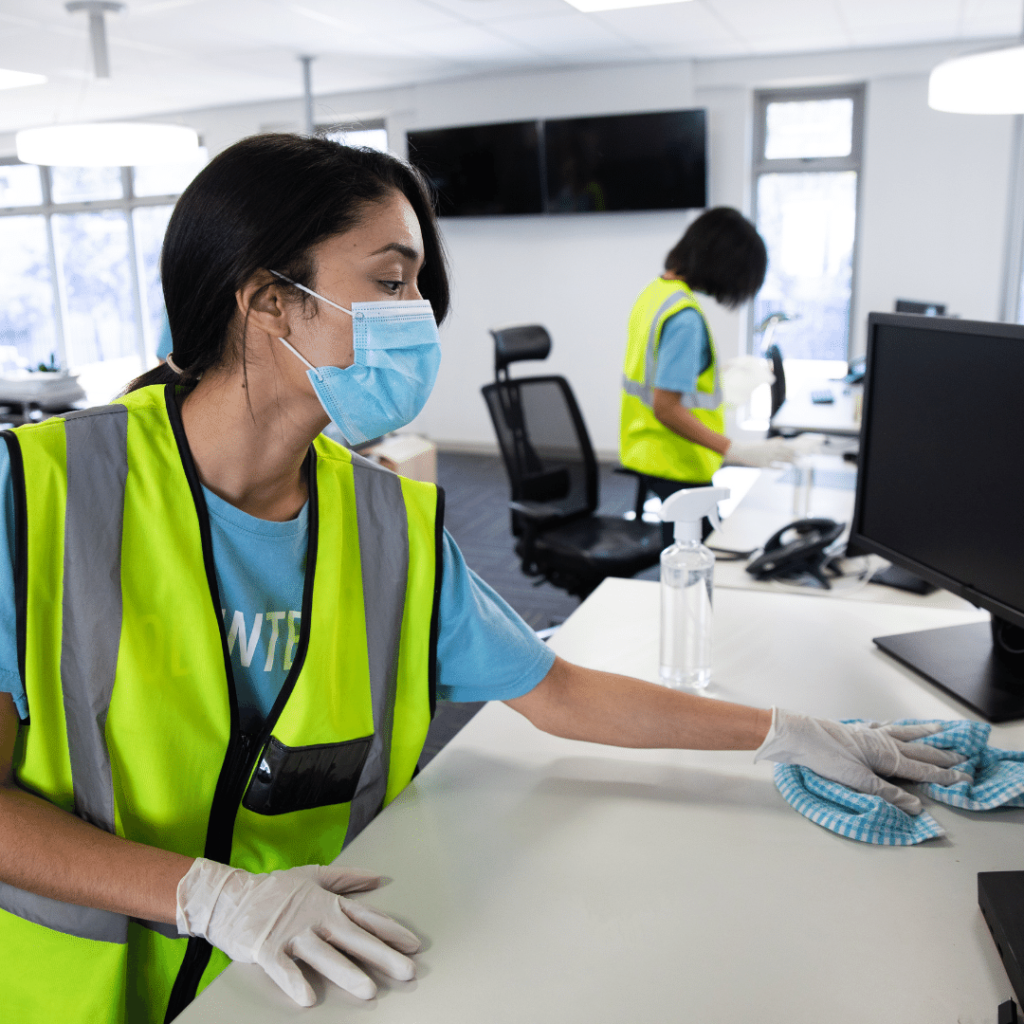 visual image of commercial cleaner wiping down desk and keyboard